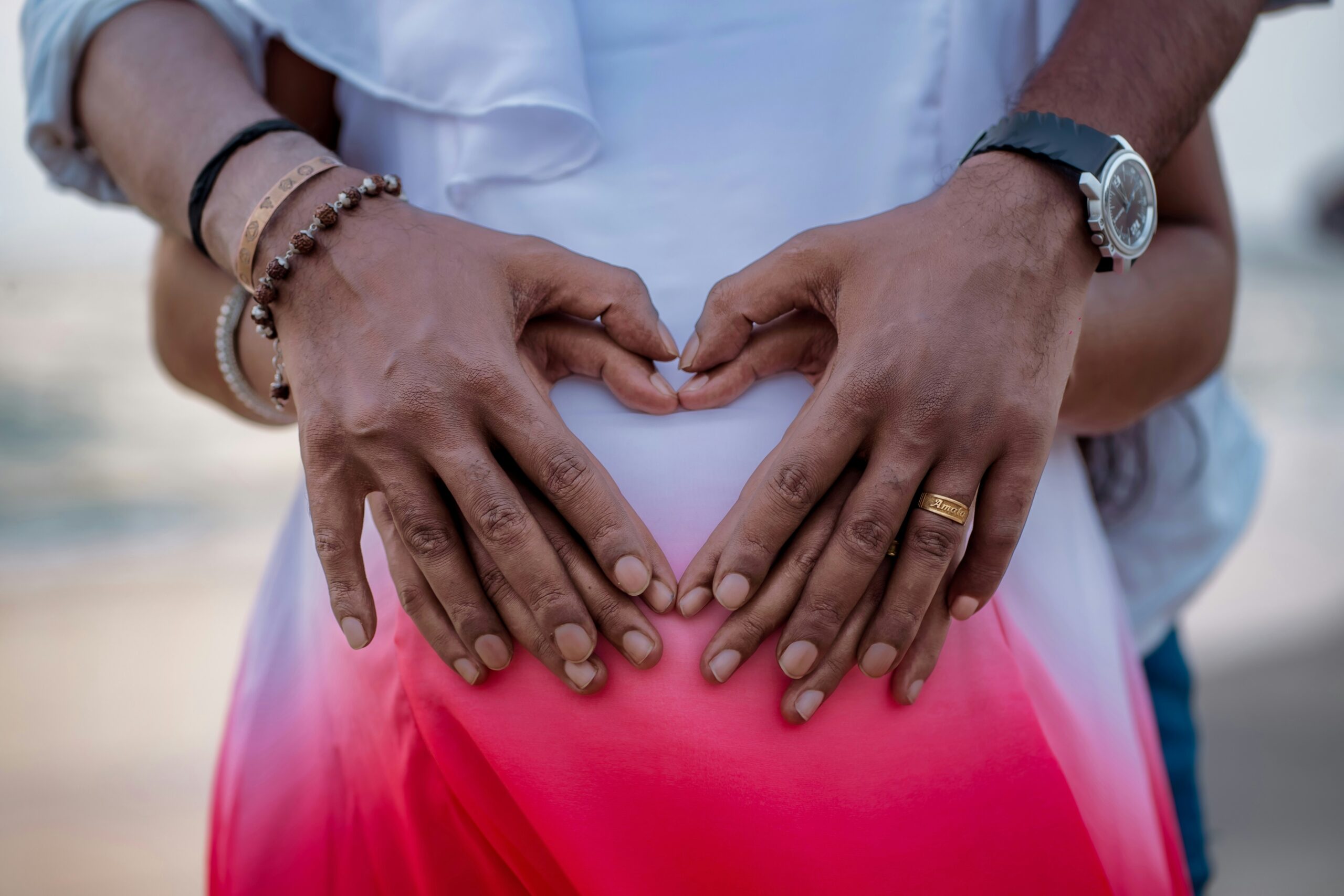 Hands forming a heart on a pregnant belly